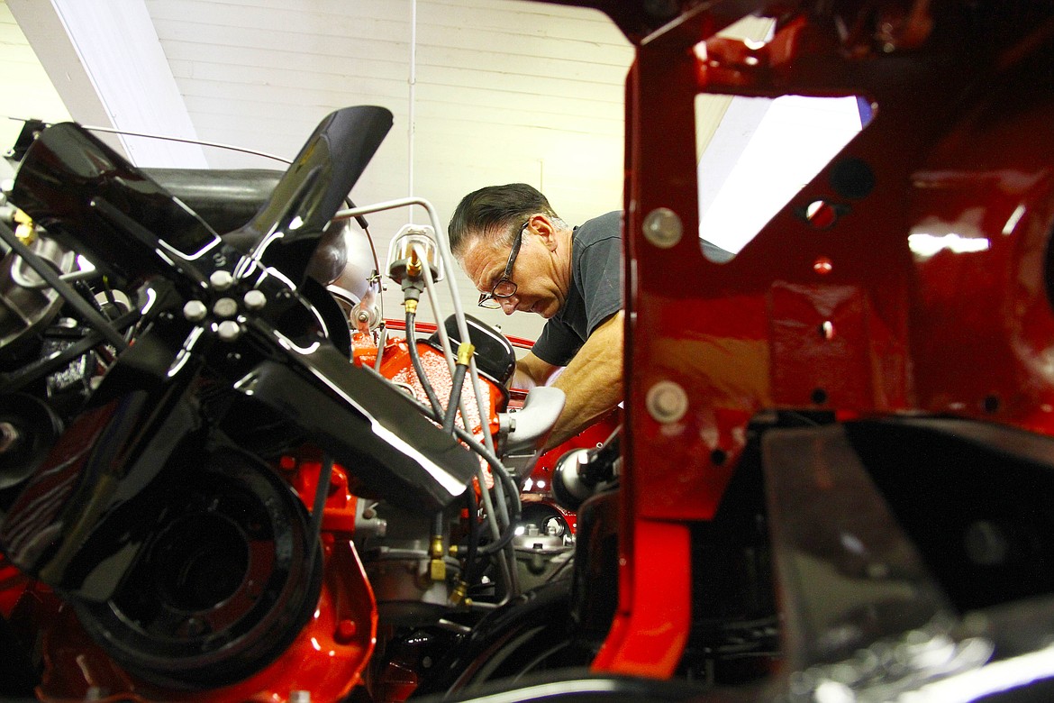 Tim Hein works to replace gaskets and seals in the dashboard area around where the vehicle's steering column will be installed.