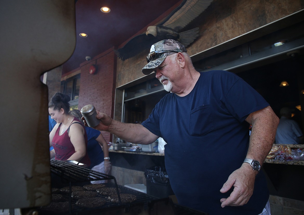 Larry George seasons burgers during the weekly barbecue at the Eagles Lodge in Coeur d'Alene on Thursday. (LOREN BENOIT/Press)