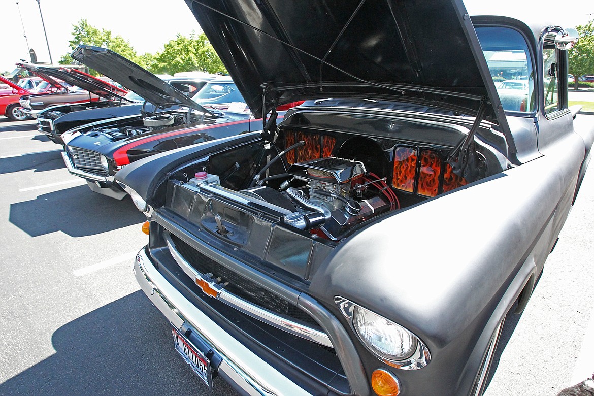 A black 1955 Chevy Pickup belonging to Ken Rachels of Post Falls is displayed among other custom and classic vehicles Saturday during the North Idaho Classics Car Club&#146;s first Rod Run car show at Tedder Industries in Post Falls. Rachels hand-painted a &#147;firewall&#148; underneath the hood using a &#147;true fire&#148; technique to give the flames a more realistic appearance. (DEVIN WEEKS/Press)