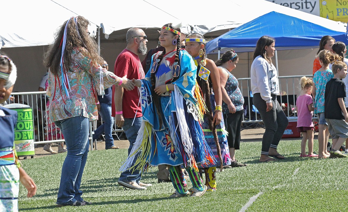 Coeur d&#146;Alene-Salish Tribal member Francheska Whitworth, 15, center, shakes hands with other dancers and guests during a round dance of the Julyamsh Powwow on Saturday. About 250 tribal dancers and six drum groups are performing and competing throughout the weekend. (DEVIN WEEKS/Press)