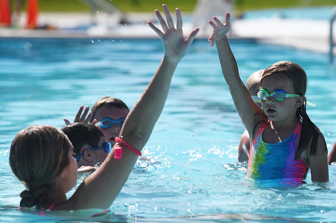 Swim instructor Hailey Fennell demonstrates the backstroke to a group of young swimmers at Woodland Water Park in Kalispell on Wednesday, July 18. (Casey Kreider/Daily Inter Lake)