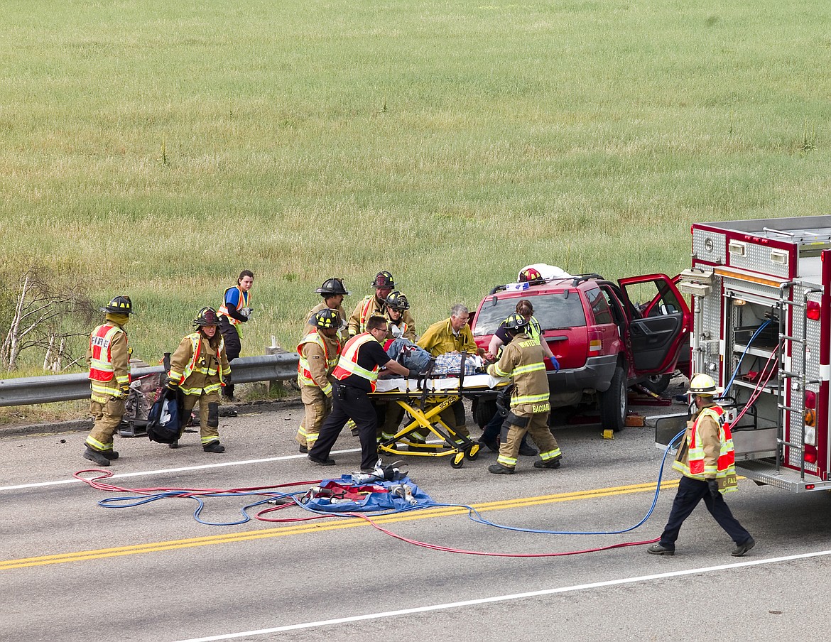 Columbia Falls firefighters and Three Rivers EMS crews transport a man to the hospital after the Jeep he was driving struck a semi tractor trailer on U.S. Highway 40 and hit a guardrail.