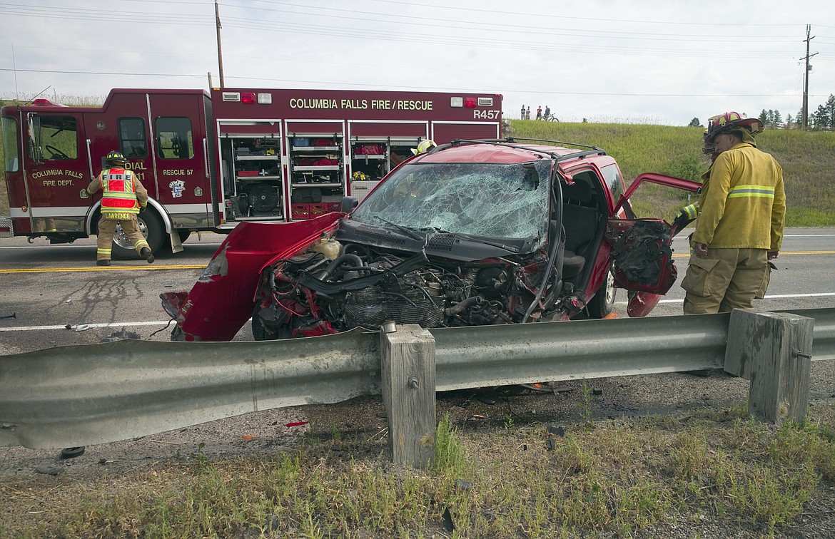 Columbia Falls firefighter Ron Ross looks over the Jeep after the victims had been extricated.