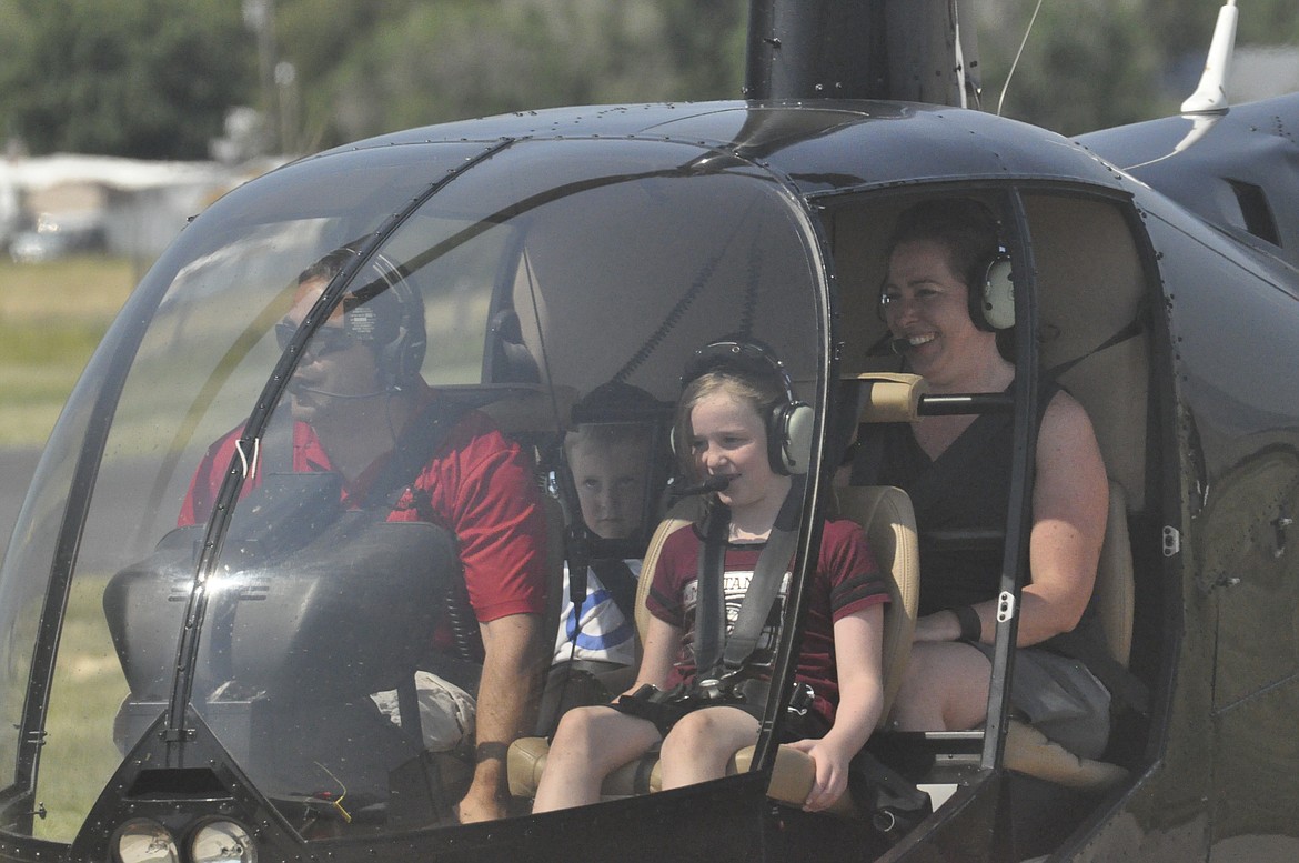 CLOCKWISE FROM bottom left are pilot James Dawe, Kade Behm, Holly Behm and Shyla Behm. Dawe took the family on a 10-minute helicopter ride to the Mission Mountains and back to the St. Ignatius airport during a fly-in over the weekend. (Photos by Ashley Fox/Lake County Leader)