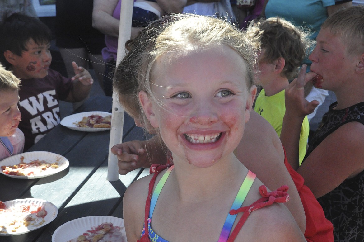 CAMPBELL MAXWELL of Helena smiles for photos  after she finishes first in the children&#146;s cherry pie-    eating contest last week at The Cove in Polson.