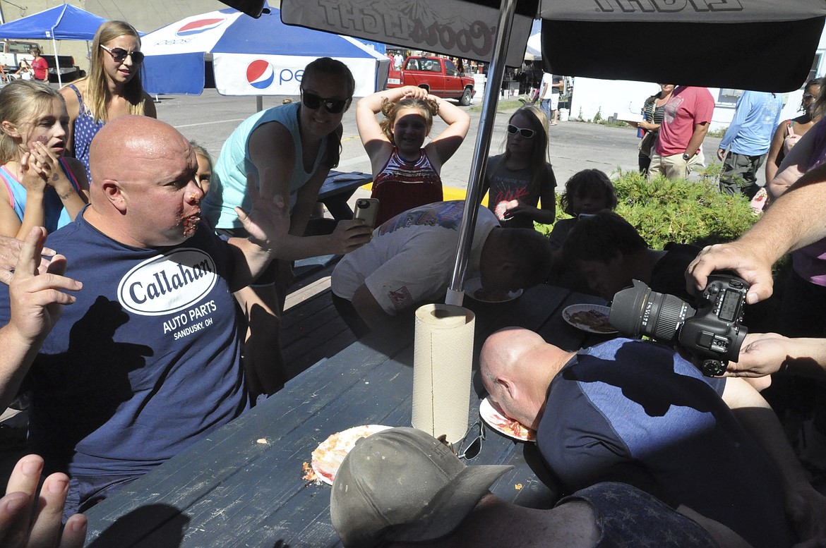 TYLER MAXWELL holds his hands up after he finishes his slice of cherry pie during a pie-eating contest at the annual Cherry Festival in Polson on Saturday, July 21. (Ashley Fox/Lake County Leader)