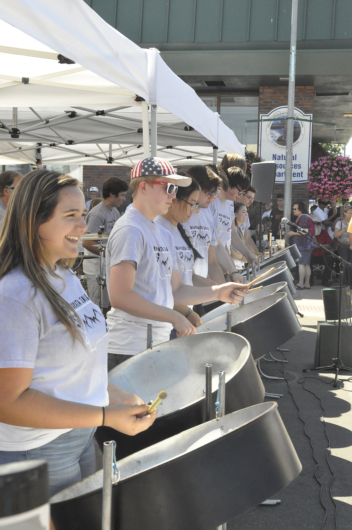 ASHLEY HUBERT, far left, smiles as she plays a steel drum during a Bram Brata performance at the Cherry Festival last weekend. (Ashley Fox/Lake County Leader)