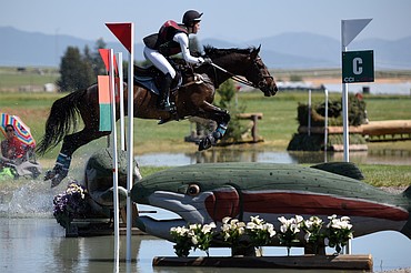 Shannon Harger rides her horse King of Hearts over a water jump on the cross-country course during The Event at Rebecca Farm on Friday. (Casey Kreider/Daily Inter Lake)