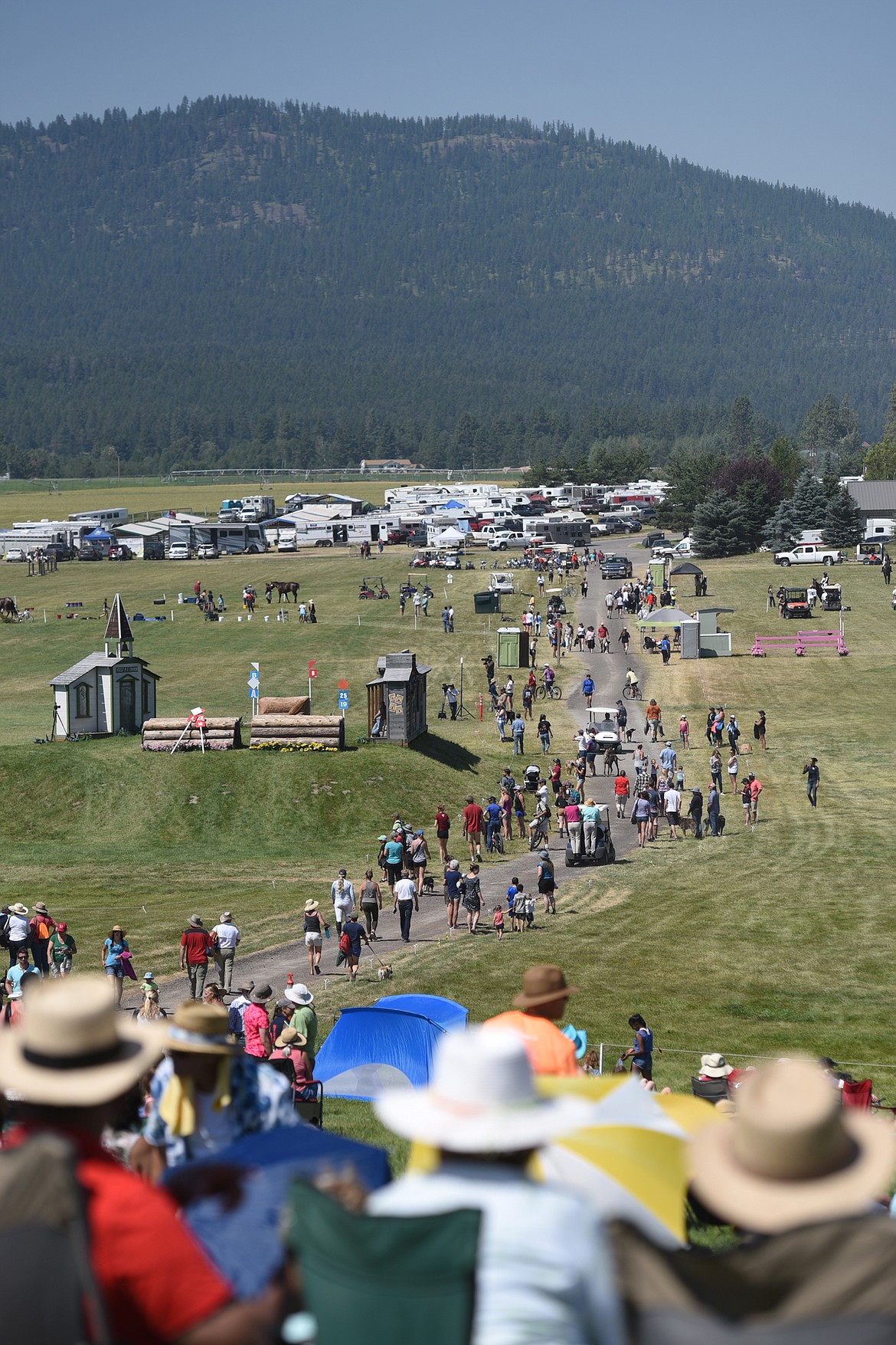 Attendees walk along one of many lanes and pathways up to Spectator Hill to access panoramic views of the cross-country course during The Event at Rebecca Farm on Saturday. (Casey Kreider/Daily Inter Lake)