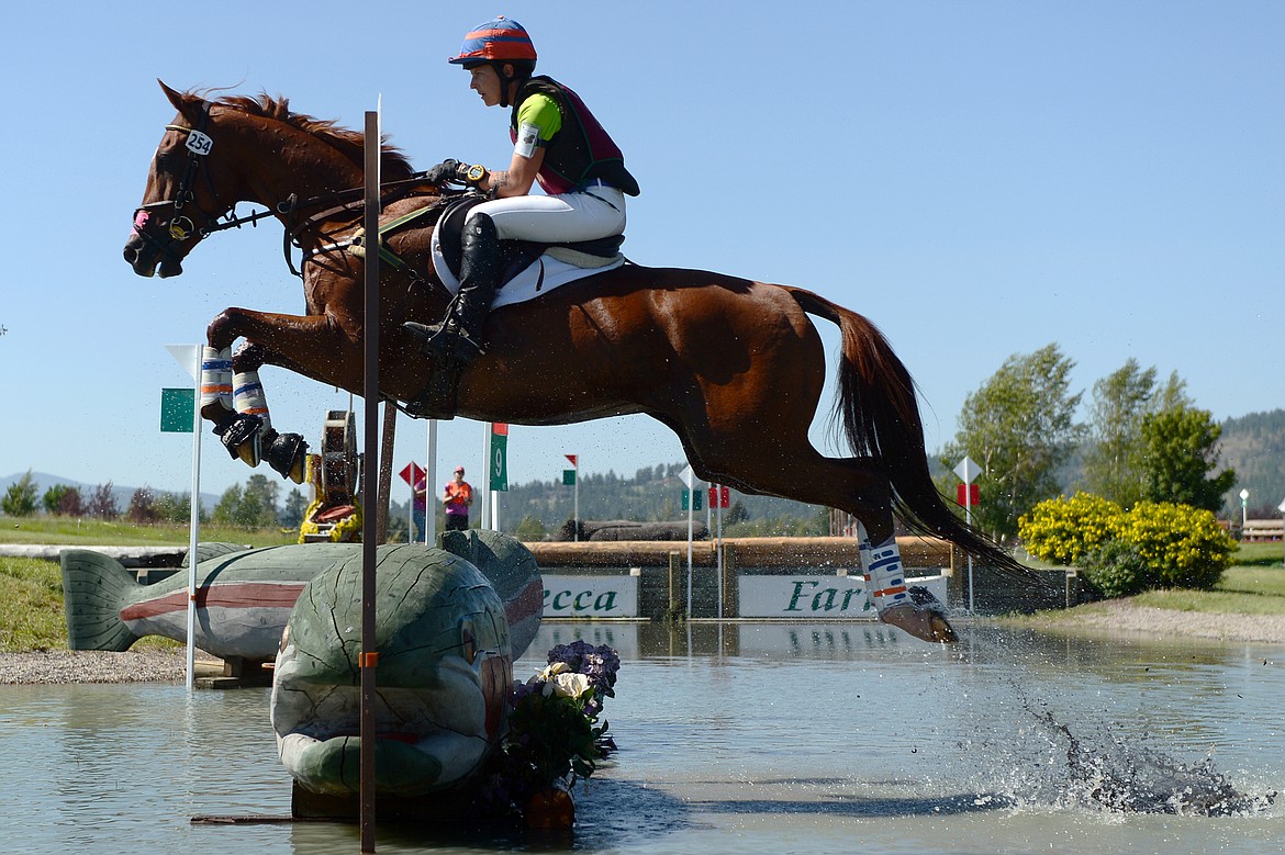 Meaghan Marinovich rides her horse Red Lion over a water jump on the cross-country course during The Event at Rebecca Farm on Friday. (Casey Kreider/Daily Inter Lake)