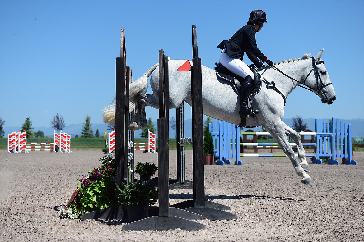 Kimberly Couper rides her horse Fashionably Late over a jump in Show Jumping Ring 3 in the Senior Open Novice C category during The Event at Rebecca Farm on Friday. (Casey Kreider/Daily Inter Lake)