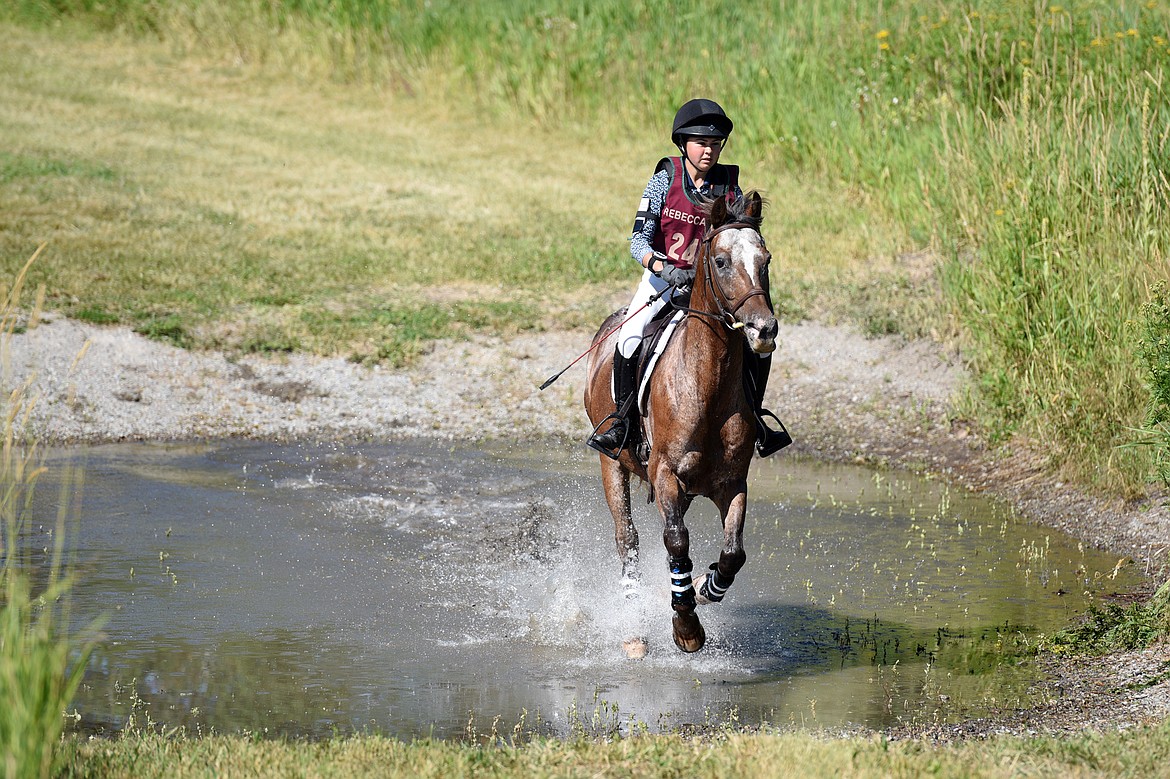 Alexandra Nigg rides her horse Kuna Awassis through a water obstacle on the cross-country course during The Event at Rebecca Farm on Friday. (Casey Kreider/Daily Inter Lake)