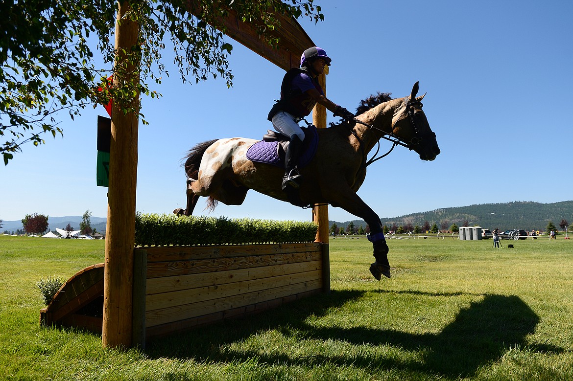 Mary Curran rides her horse Flying Colors over a jump on the cross-country course during The Event at Rebecca Farm on Friday. (Casey Kreider/Daily Inter Lake)