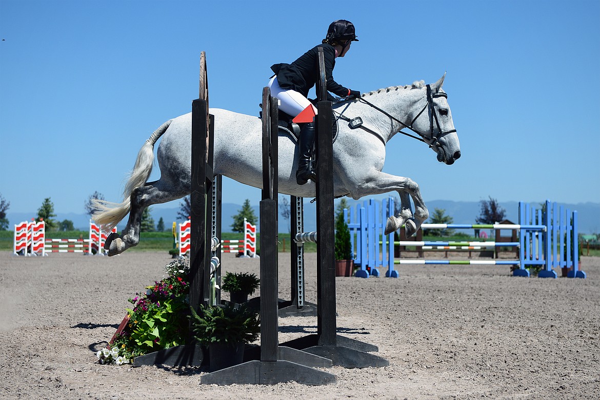 Kimberly Couper rides her horse Fashionably Late over a jump in Show Jumping Ring 3 in the Senior Open Novice C category during The Event at Rebecca Farm on Friday. (Casey Kreider/Daily Inter Lake)