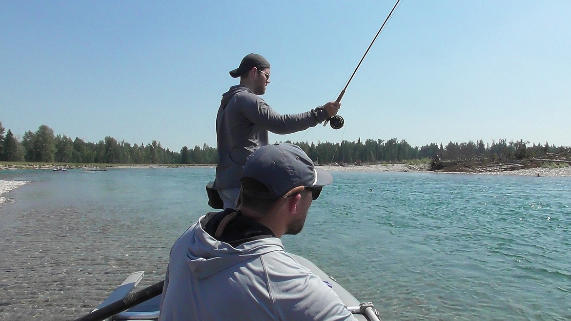 Peter Ziehli works to get a trout to his dry fly while Kalispell&#146;s Kyle Smalley mans the oars of their raft and offers his expertise during the Trout Unimited Flathead Valley chapter&#146;s annual veterans float on the Flathead River near Evergreen on Friday. (Scott Shindledecker/Daily Inter Lake)