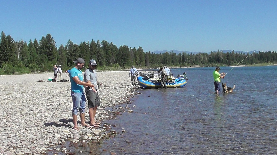 Kyle Smalley gives Peter Ziehli some instruction on fly casting before the launch of the veterans float.