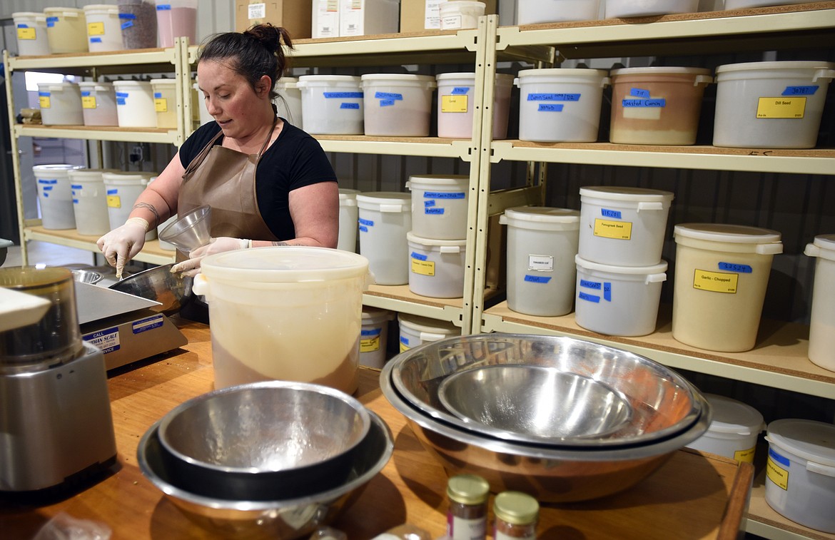 Megan Arseneau measures out spices for a custom order on Thursday, July 19, at World Spice Merchants in Columbia Falls.(Brenda Ahearn/Daily Inter Lake)