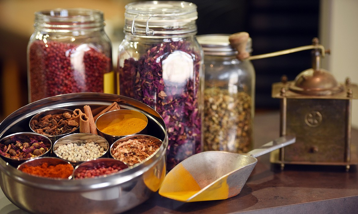 A colorful tray full of spices is paired with jars of pink peppercorns, rose petals and an antique grinder at World Spice Merchants in Columbia Falls.(Brenda Ahearn/Daily Inter Lake)