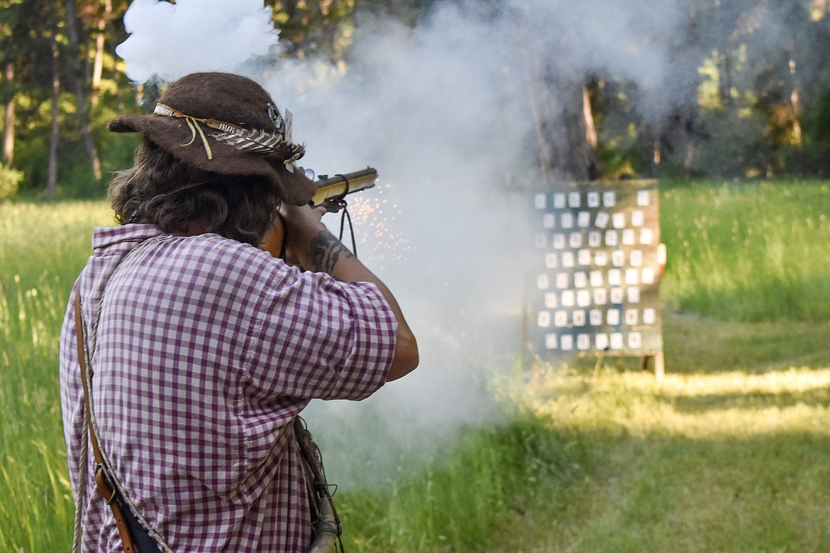 Tim Benson fires at his card on the board during on July 14 during the Two Rivers Rendezvous east of Libby. In the game, participants pay money into a pot, and if they hit a card, they get the amount on the back of the card.