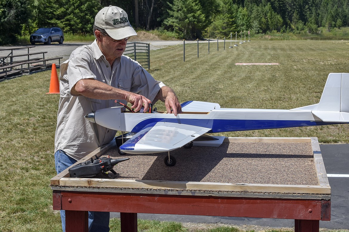 Norm Crum loads the battery into his sport plane during the annual Kootenai RC Flyers Fun Fly July 14 at the RC airport off Champion Haul Road. (Ben Kibbey/The Western News)