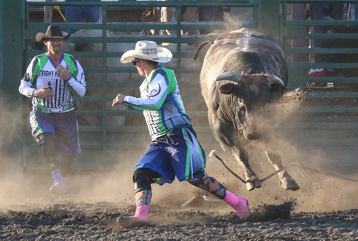 Photo by MANDI BATEMAN
Bullfighter keeping a bullrider safe during the Kootenai River Days Bull Bash.