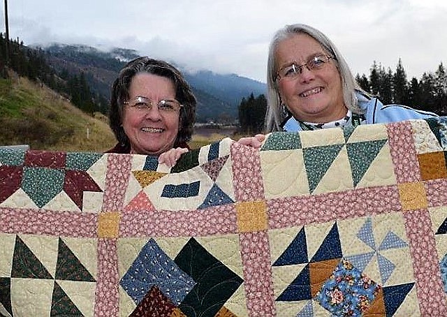 Mary Eldridge, left, has been selected as this year&#146;s featured quilter during the Cabin Fever Quilt Guild&#146;s annual show on Aug. 3 and 4 during the Mineral County Fair in Superior. Here, Eldridge and Mary Jo Berry are holding a quilt Mary made and gave to the guild&#146;s program where quilts are donated to local veterans. (Photo courtesy Cabin Fever Quilters)