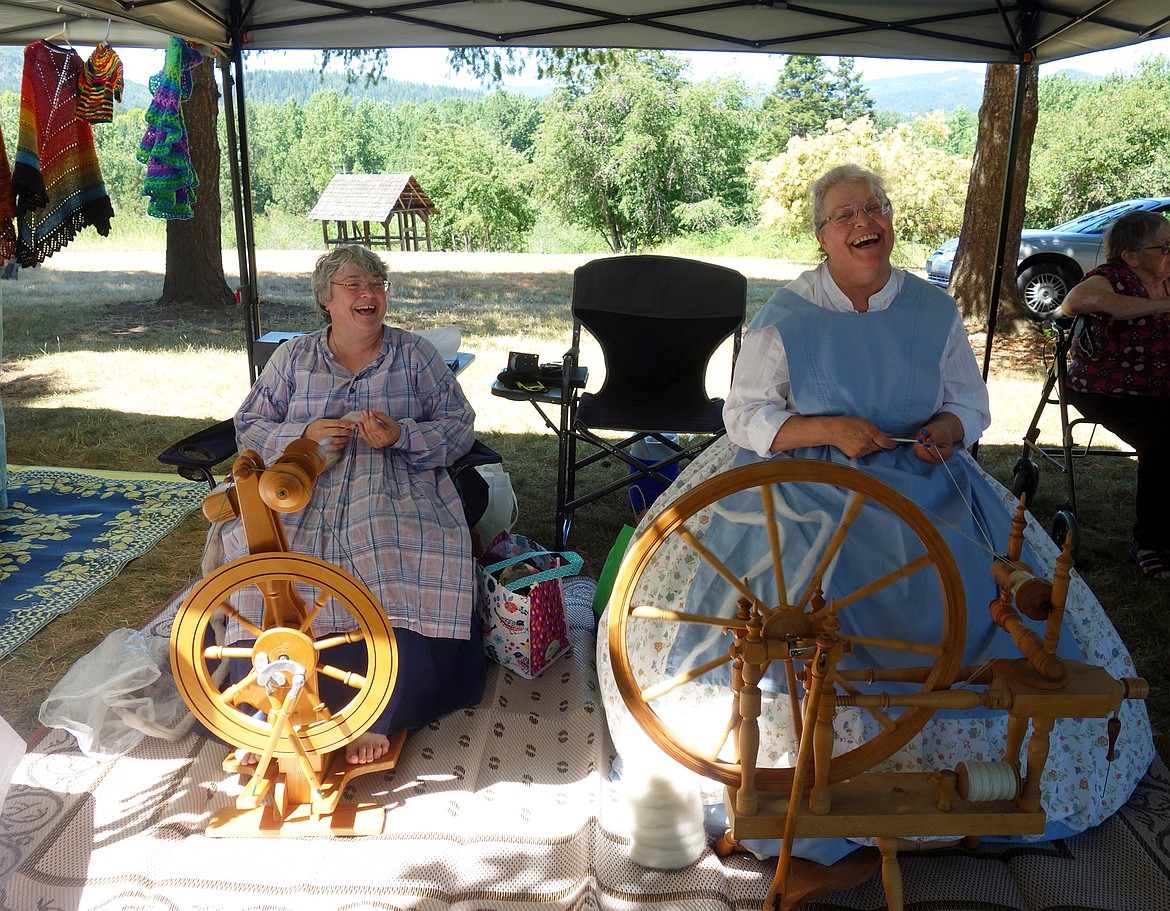 Reenactors teach visitors the art of yarn spinning with authentic spindles.