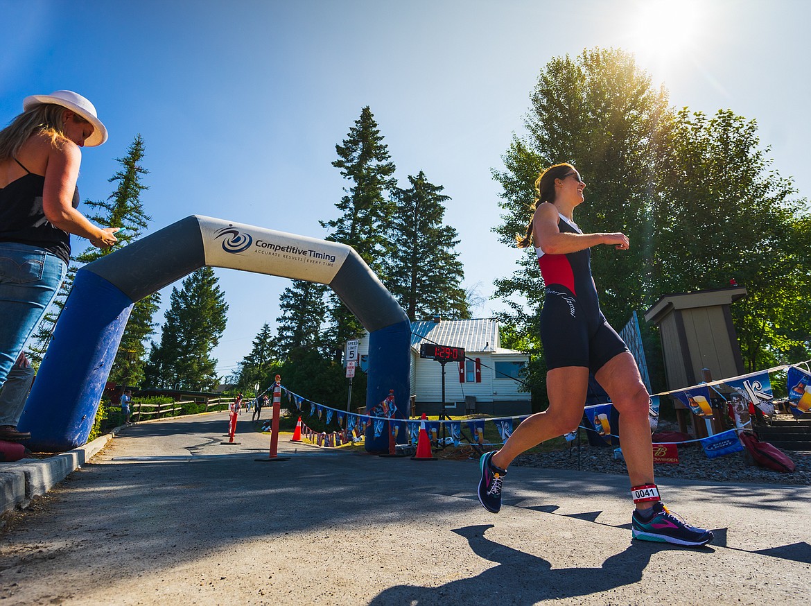 Keira Balderston of Manly, Australia crosses the finish line of the Whitefish Lake Triathlon Saturday afternoon at City Beach.