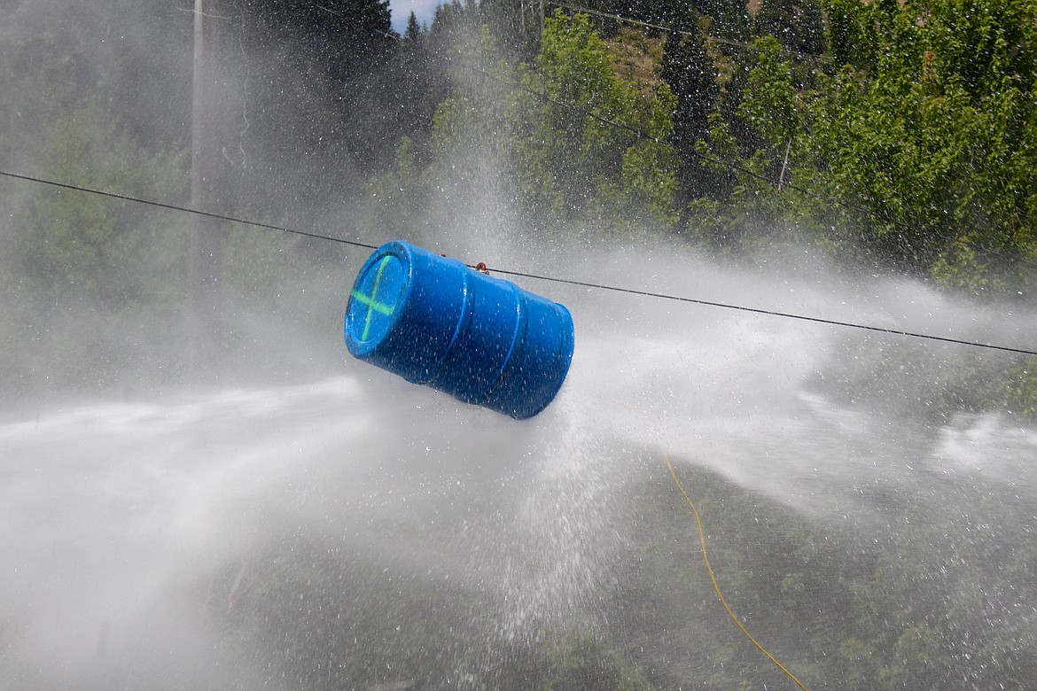 The tug of war bucket thrashes around as it is hit with water from both sides.