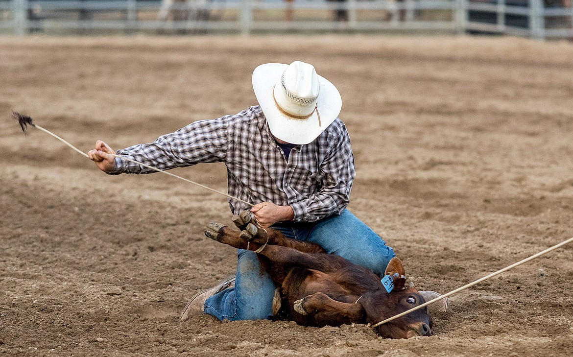 Jesse Medearis of Belgrade ties down a calf during the Kootenai River Stampede PRCA Rodeo at J. Neils Arena in Libby Friday. (John Blodgett/The Western News)