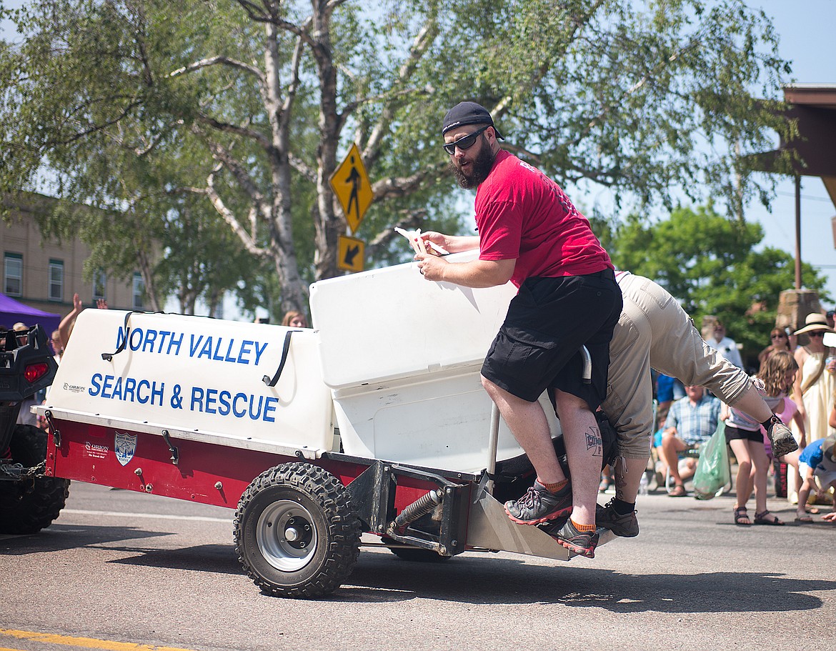 The North Valley Search and Rescue float throws out frozen treats to the crowd.