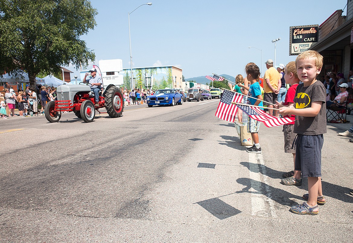 Benjamin Fournier waves a flag at the parade.