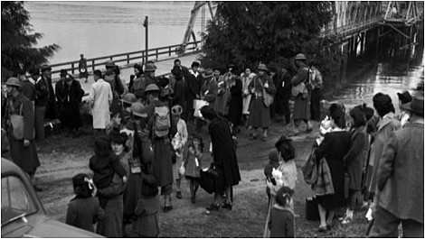 MUSEUM OF HISTORY AND INDUSTRY
On March 30, 1942, Japanese Americans under armed guard at Eagledale Ferry Dock on Bainbridge Island, Wash., await boarding the Kehloken to begin their journey to internment camp at Manzanar in California for the duration of World War II &#151; by executive order of President FDR.