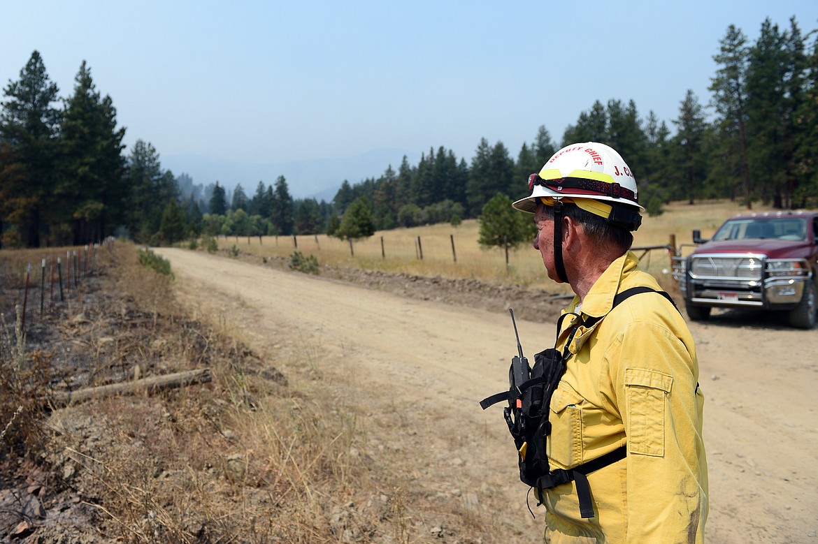 A firefighter who did not wish to be identified looks up Garden Creek Road toward the Garden Creek Fire near Hot Springs on Thursday. (Casey Kreider/Daily Inter Lake)