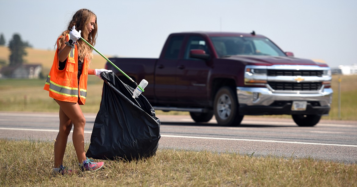 Meaghan Fisher, 17, picks up trash along U.S. 93 north of Kalispell on Tuesday, August 7.(Brenda Ahearn/Daily Inter Lake)