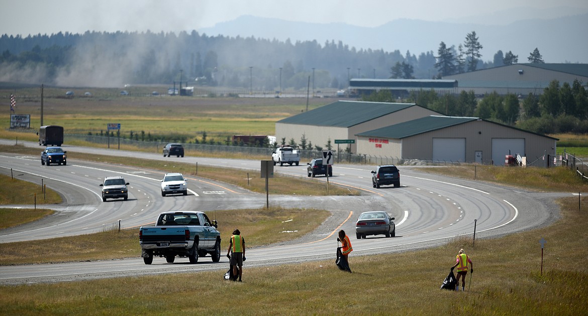 From left, Rylin Madsen, 18, Meaghan Fisher, 17, and Clara Vandenbosch, 18, pick up trash along U.S. 93 north of Kalispell on Tuesday, August 7. The three are all summer employees of Flathead County Parks and Recreation.(Brenda Ahearn/Daily Inter Lake)