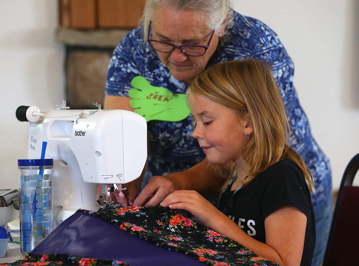 Photos by LOREN BENOIT/Press
Volunteer Ellen Marlatt helps Elise Kopp, 9, sew a backpack during the annual youth sewing and quilting camp Tuesday afternoon at the Coeur d&#146;Alene Shrine Club Event Center in Hayden.