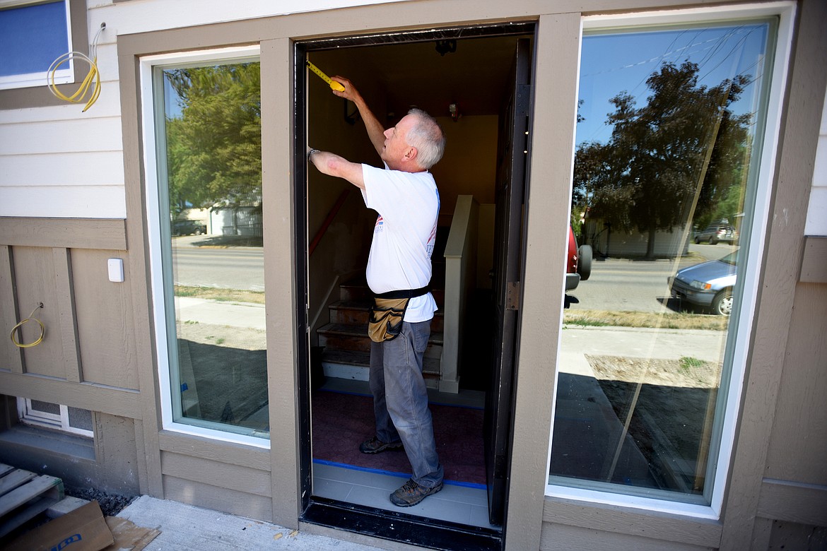 Sparrow&#146;s Nest of Northwest Montana board member and volunteer Bret Luedke installs trim around the front door of the Kalispell residence on Monday, July 30. The goal is to have the house move-in ready before the first day of school in late August. (Brenda Ahearn/Daily Inter Lake)