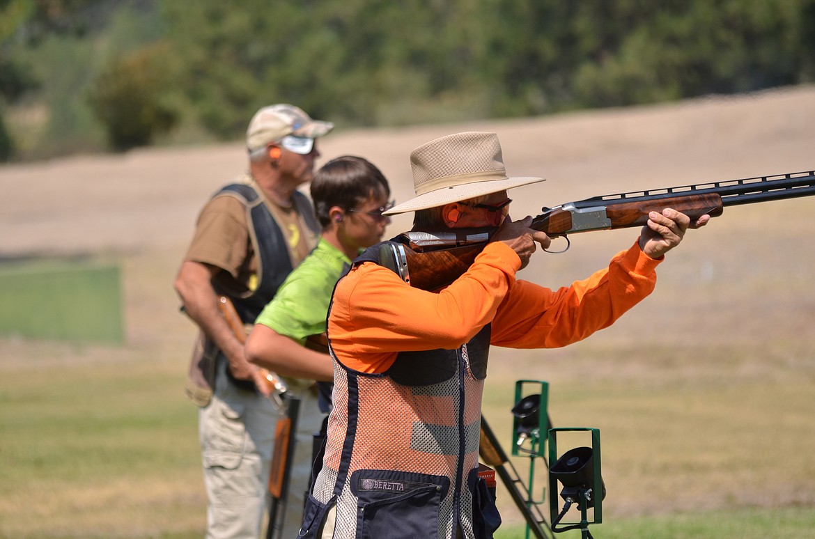 Other shooters watch as Kermit Chicha steps up to line out his target. (Erin Jusseaume/ Clark Fork Valley Press)