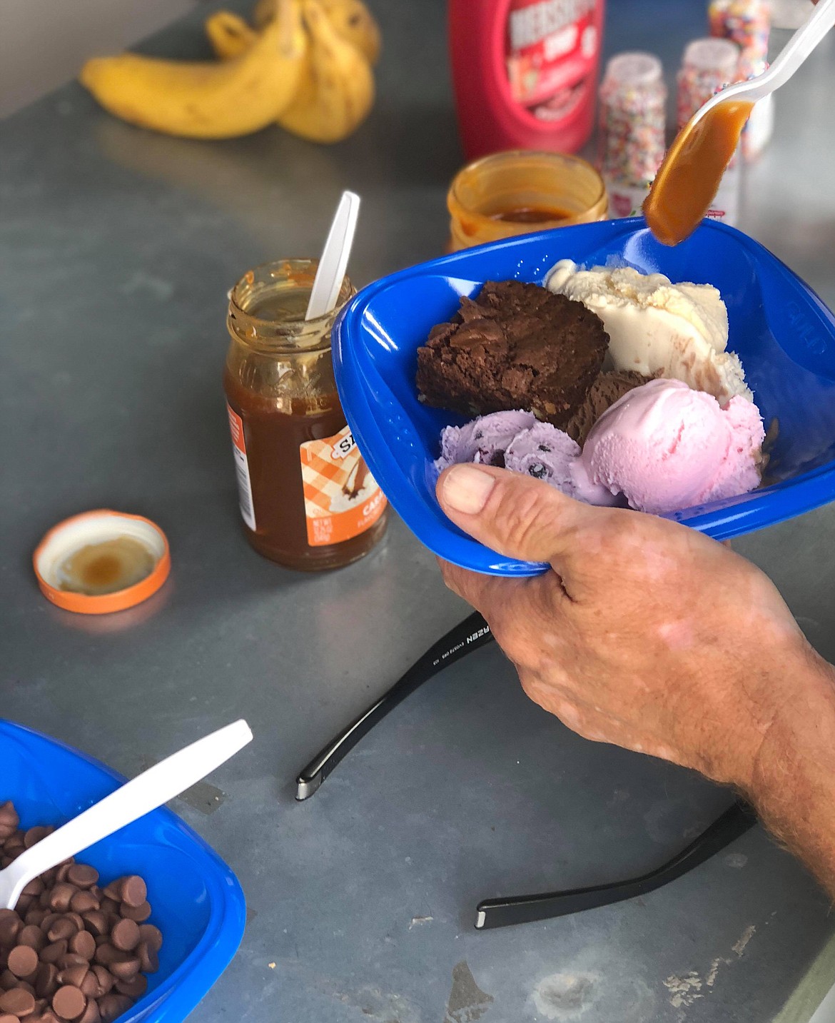 Sweet treats are added to a bowl of ice cream at the CASA Ice Cream Social at the Sanders County Fairgrounds. (Photos by Erin Jusesaume/ Clark Fork Valley Press)