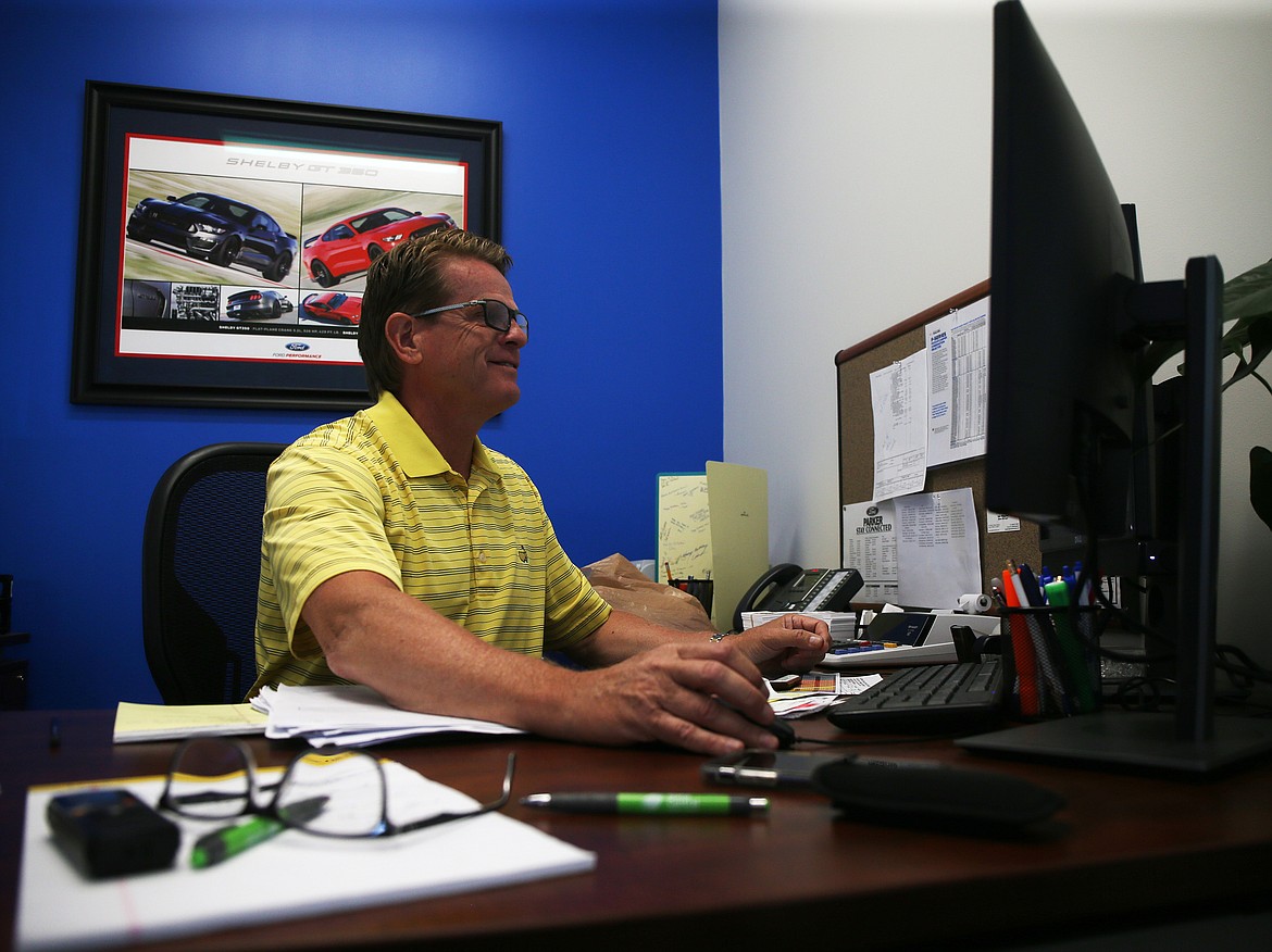 Photos by LOREN BENOIT/NIBJ
Mike catches up on email at Mike White Ford of Coeur d&#146;Alene. White purchased the dealership from the Parker family after having worked for the family as a salesman and general manager.