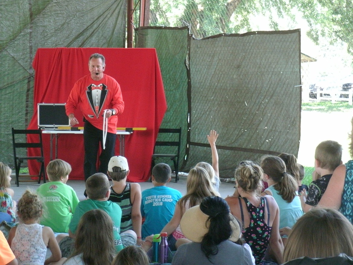 Photos by PHOENIX JOLLEY
Dave the Magic Man asks the children for magic words to assist him with a rope trick during his Aug. 1 show at the Boundary County Fairgrounds. The event celebrated the Boundary County Library&#146;s summer reading program reaching a goal of 7,135 books read by area children.