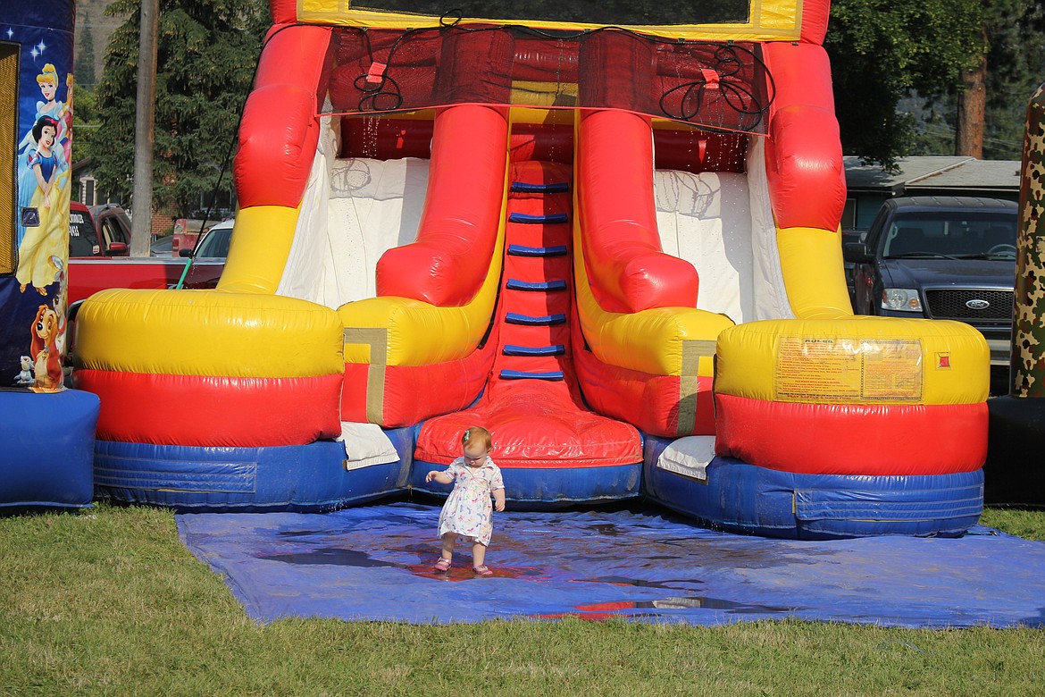 ONE-YEAR-OLD Violet Moree plays in the water in front of a giant bouncy slide at the Mineral County Fair in Superior.