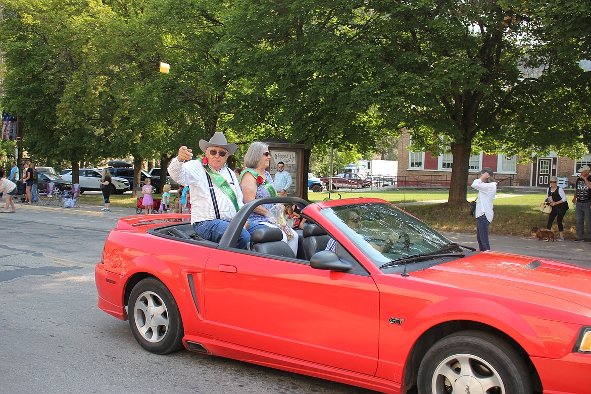 CHARLIE STEVENS tosses a candy with wife, Peggy, as they drive by the crowd on River Street in Superior. The Stevens were this year&#146;s Smokin&#146; Hot Mineral County Parade Marshals.