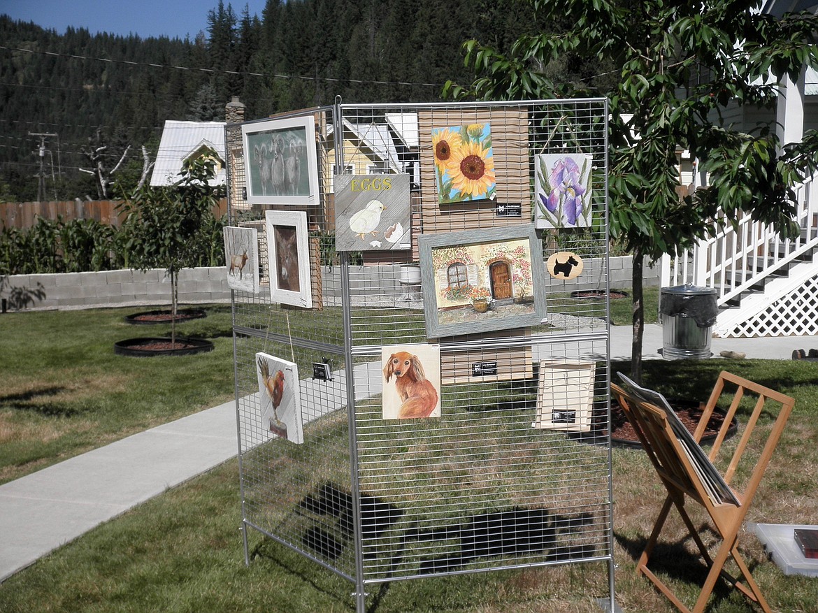A display rack of Lorna Barrowman&#146;s paintings set in Charles and Jan Bazja&#146;s yard by his huge vegetable garden and possibly the only Silver Valley vineyard.