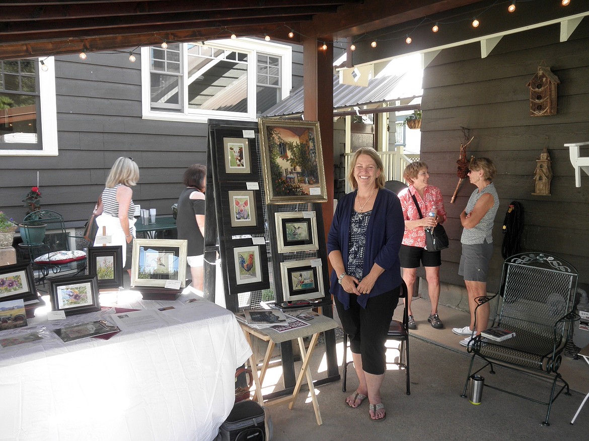 Artists Karen Conrad (front center) displays her work while guests visit with other artists in the background.