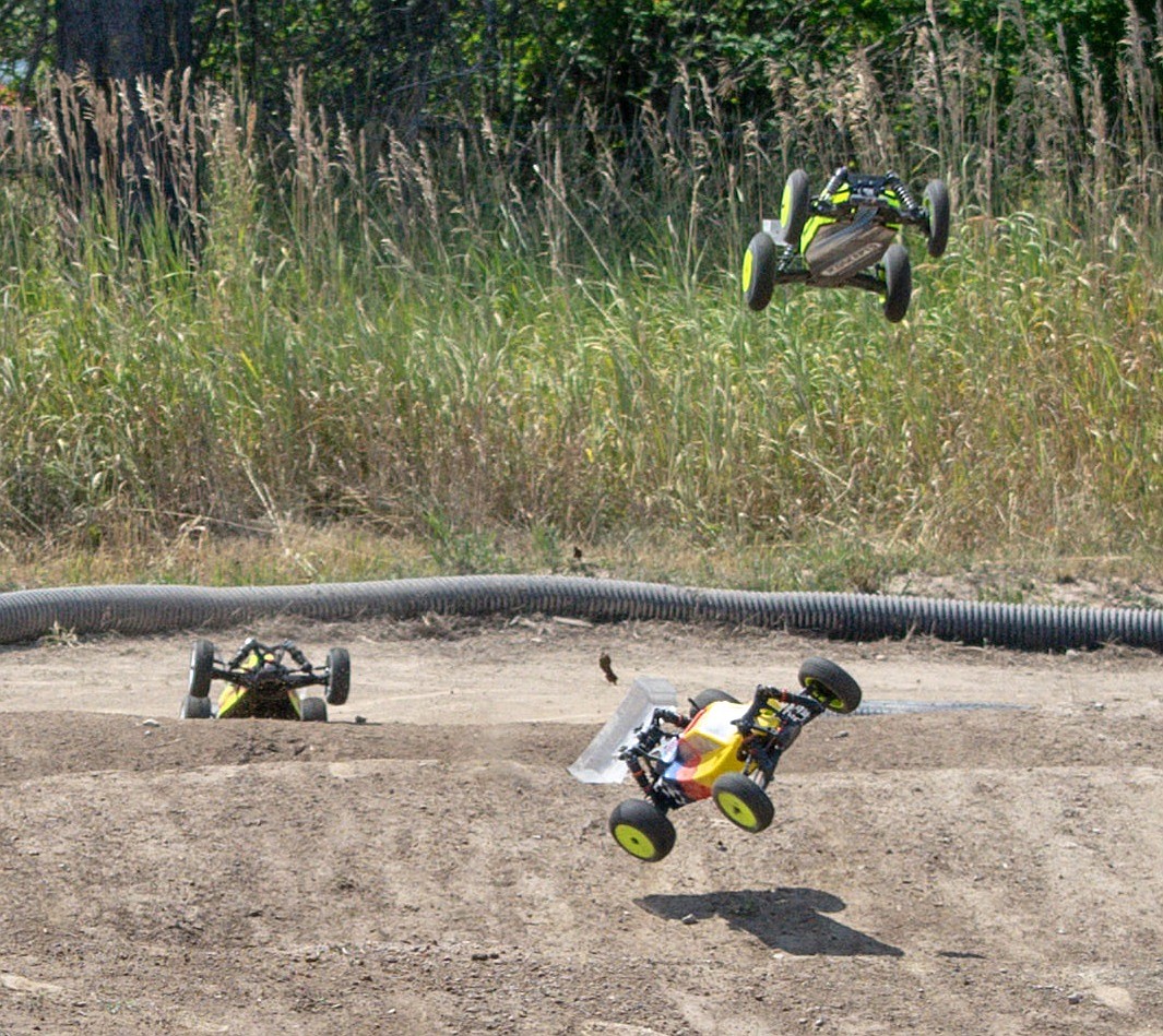 Three &#147;buggy&#148; RC racers fly over the jumps during final races of the Kootenai RC Racers&#146; Hot August Showdown on Sunday. (Ben Kibbey/The Western News)