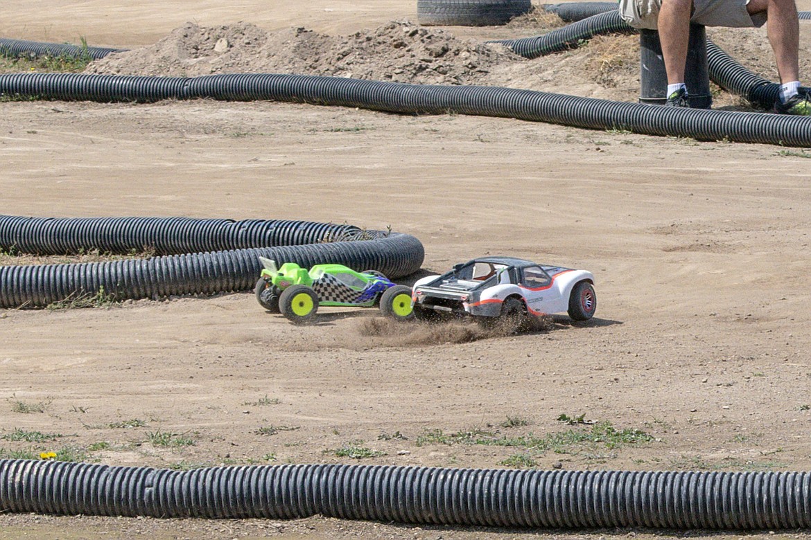 Dirt flies as two RC racers jockey for position in the turn during final races of the Kootenai RC Racers&#146; Hot August Showdown on Sunday. (Ben Kibbey/The Western News)