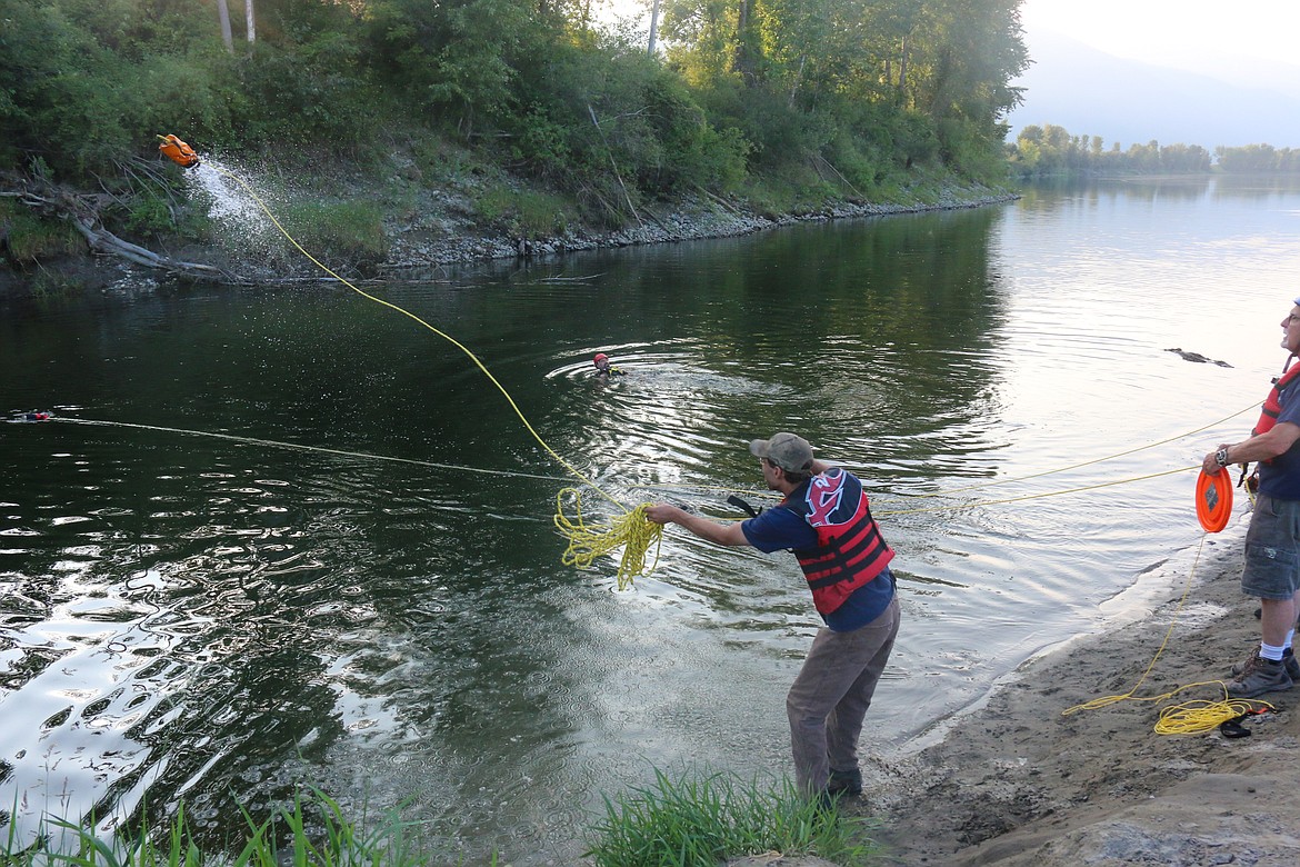 South Boundary Firefighters participate in water rescue training on July 26 at the mouth of Deep Creek.
Clockwise from right:  After the first throw, the throwbags were filled with water to give them weight; the rope is thrown as close as possible to the mock victim; the mock victim is pulled to shore.