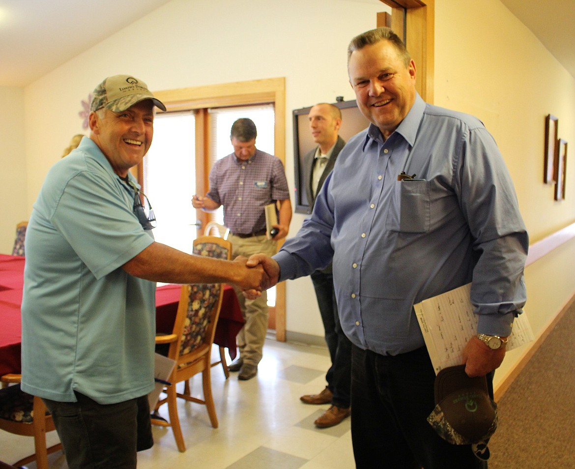 Mineral County Commissioner Duane Simons, left, shakes hands with Montana Sen. Jon Tester during a meeting about infrastructure held on July 27 in Superior. (Kathleen Woodford/Mineral Independent)